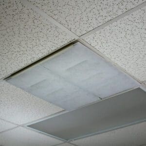 Ceiling with acoustic tiles featuring a rectangular Breathe Easy – Diffuser Air Filter.