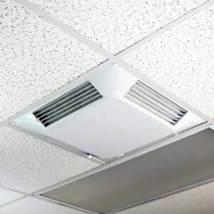 Ceiling with a Comfort First Filtered Diffuser, featuring a square white air vent panel next to tiled ceiling panels.