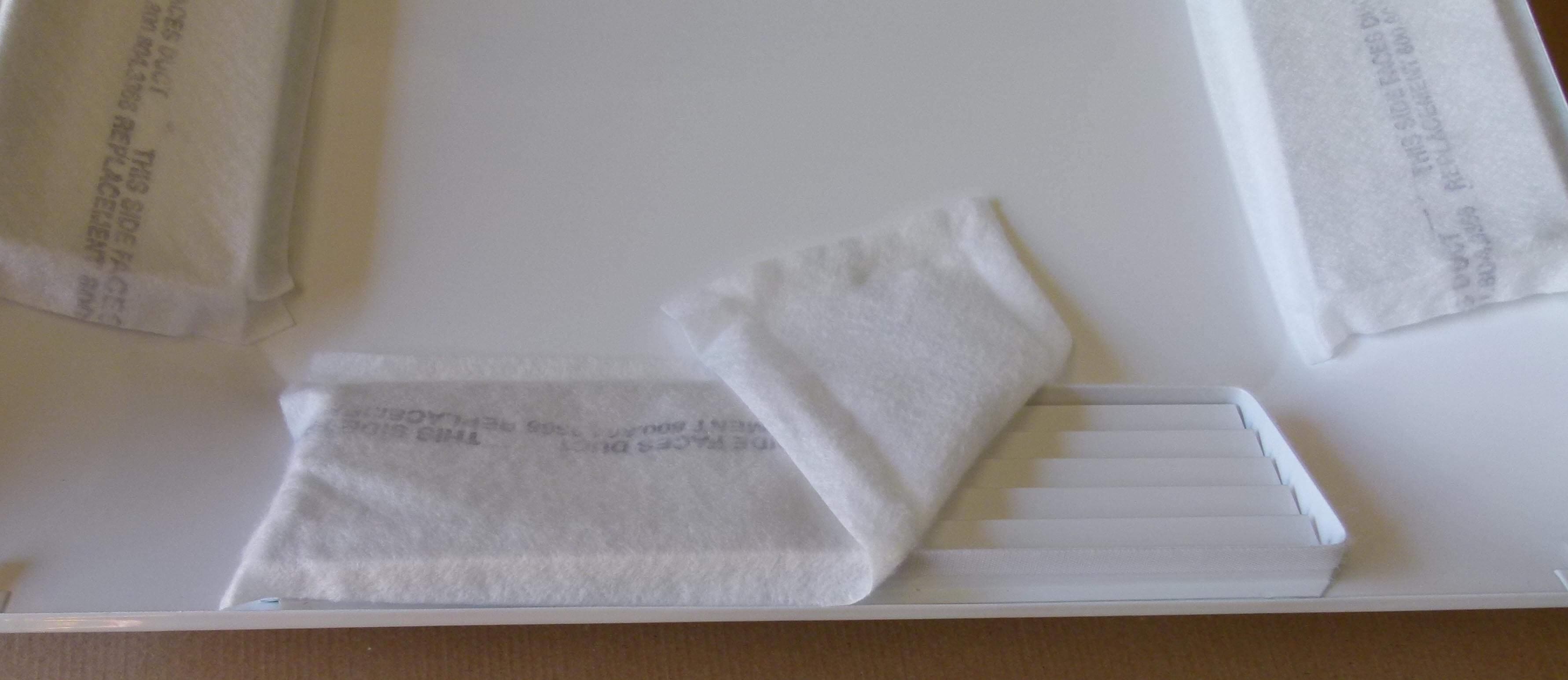 A folded white towel on a white surface.