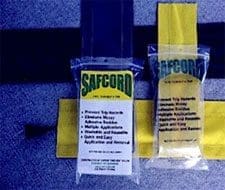 Two clear "Safcord" packages are on a textured surface; one stands upright, the other lies flat, showing yellow fabric inside.